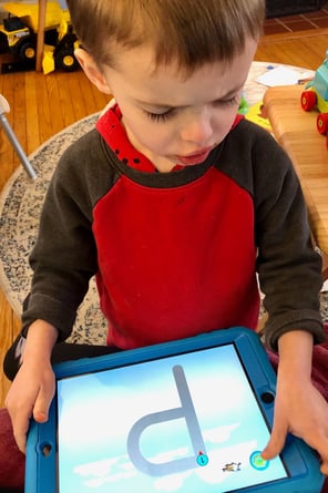 CHild playing with an EBLI developed learning app.
